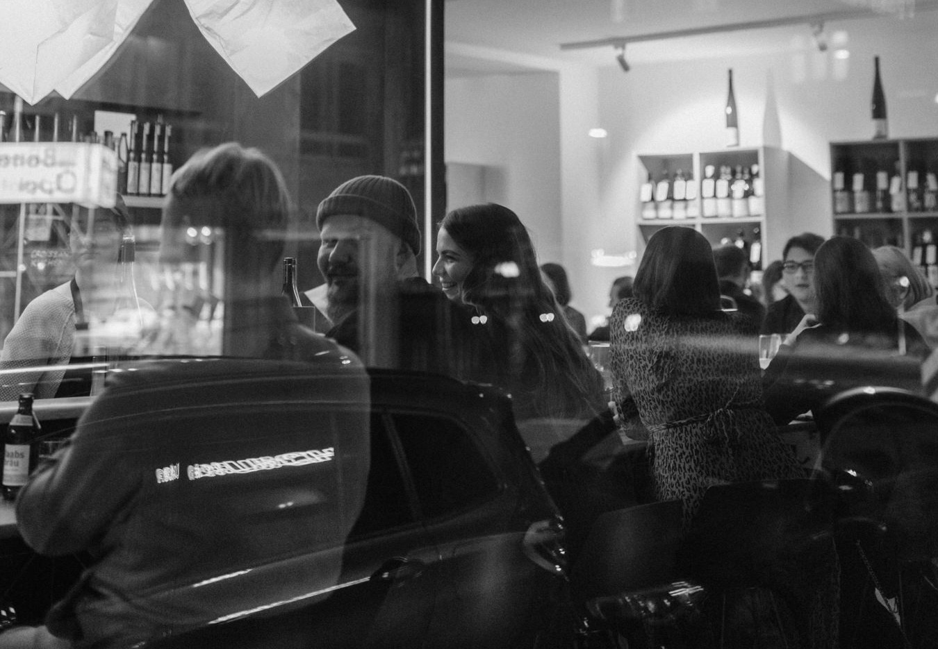 Schwarz-weiß Aufnahme von Besuchern in einer Bar.